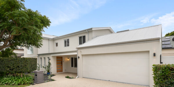 Newly renovated front of a Perth home, with double garage and driveway next to a lush garden.
